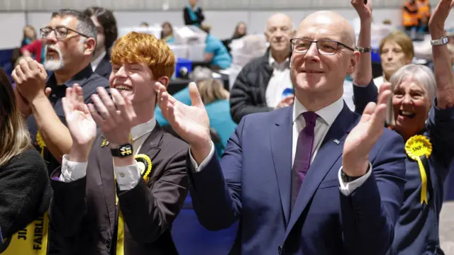 John Swinney and SNP supporters applauding