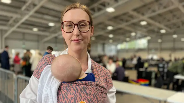 A mother holding her son as he sleeps