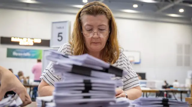 A woman counting ballot papers