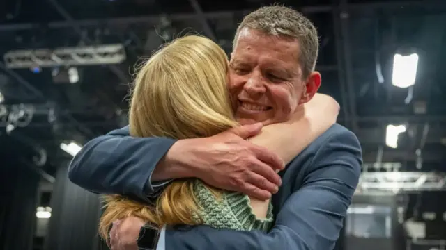 Rhun ap Iorwerth is hugging a woman, smiling