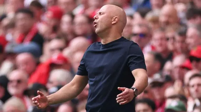 Liverpool manager Arne Slot looks disappointed. He is wearing a black t-shirt