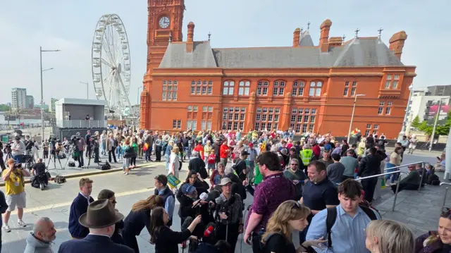 A group of people in front of the Terracotta Pier head building