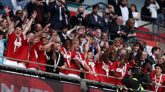 Charlton captain Greg Docherty lifts the League One play-off trophy at Wembley