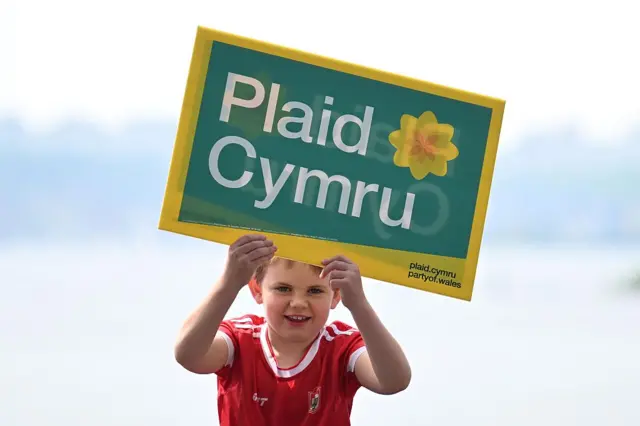 A child holding a Plaid Cymru sign