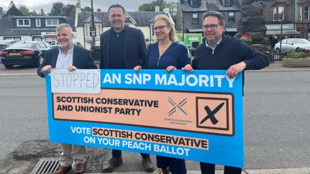 Finlay Carson, Russell Findlay, Rachel Hamilton and Craig Hoy holding up a peach ballot banner.