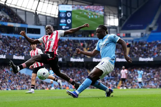Jeremy Doku (right) and Brentford's Michael Kayode in action