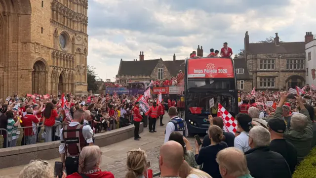 The bus drives through the fans outside the cathedral
