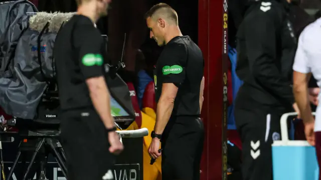 Referee Steven McLean checks the VAR monitor