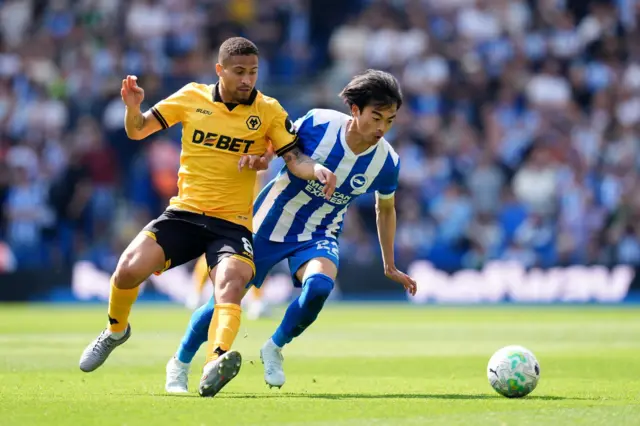 Wolverhampton Wanderers' Joao Gomes (left) and Brighton and Hove Albion's Kaoru Mitoma battle for the bal
