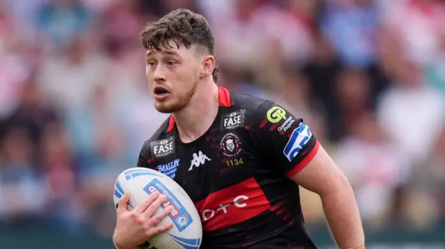 Wigan's Jack Farrimond carries the ball against St Helens