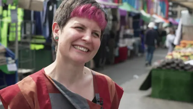 Zoe Garbett being interviewed in an outdoor market in Hackney