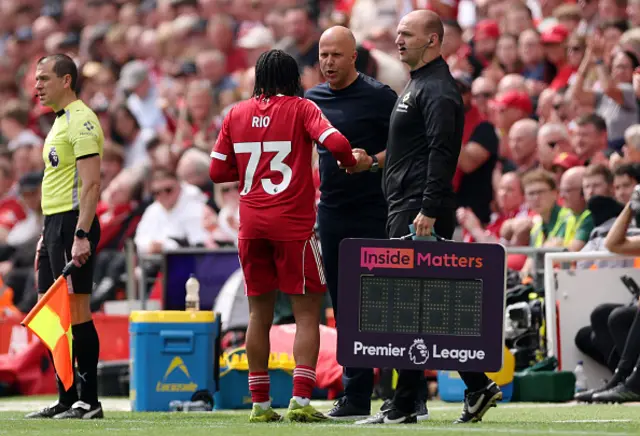 Rio Ngumoha of Liverpool interacts with Arne Slot