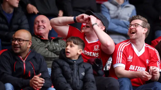 Boro fans gesticulate having binoculars