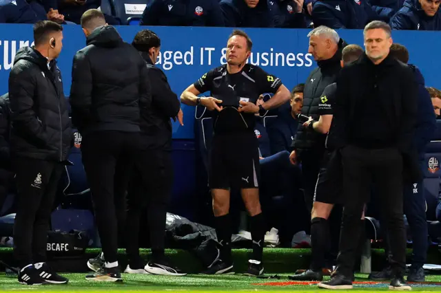 Fourth Official David Rock prepares to replace the injured referee Martin Coy
