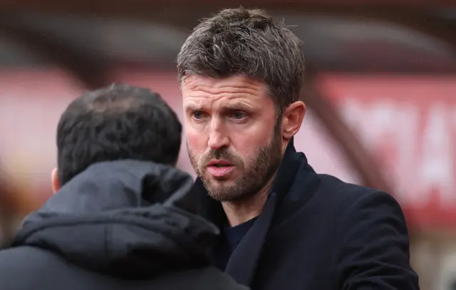 Michael Carrick, Manager of Manchester United, interacts with Regis Le Bris