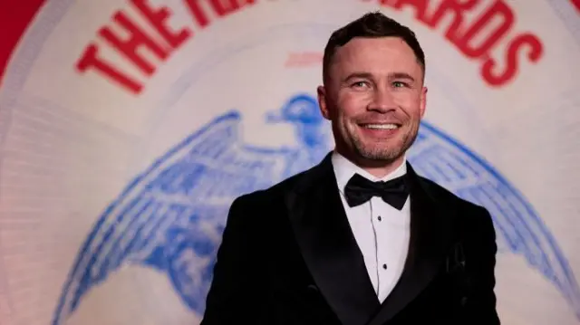 Carl Frampton smiles in a suit on the red carpet