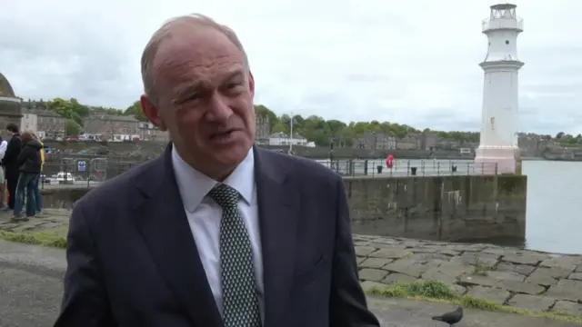 Lib Dem leader Ed Davey speaks from Ediburgh wearing dark suit jacket, white shirt and patterned tie