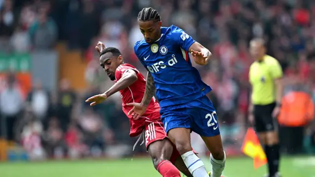A Chelsea player fends off a Liverpool player