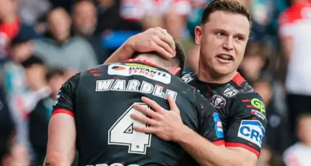Wigan players celebrate a try against St Helens