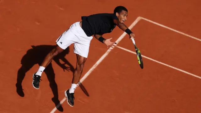 Felix Auger-Aliassime serves