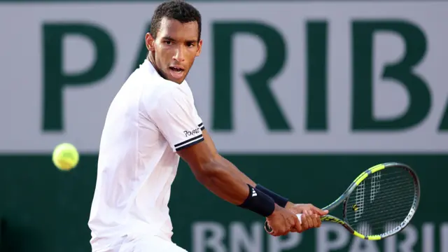 Felix Auger-Aliassime hits a backhand