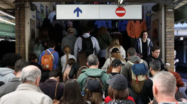 People exit the platform at South Kensington station during a reduced service caused by tube strike