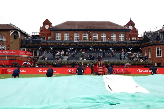 Ground staff cover the court