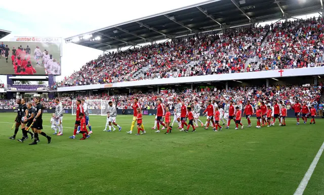 Players and match officials make their way out onto the pitch