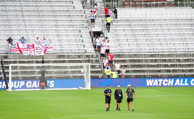 Ground staff inspect the pitch as the kick-off