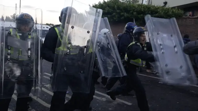 Screen grab taken from video of a line of police officers with riot shields clashing with protesters