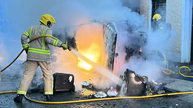 Vehicles set on fire by protesters on Lendrick Street in Belfast.