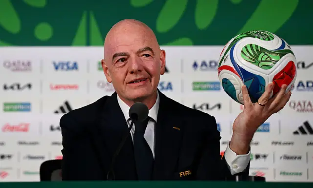 Gianni Infantino holding the World Cup ball in his left hand