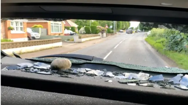 Back window of car smashed with stone