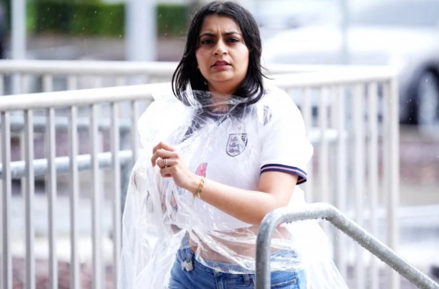 An England fan arrives in the rain