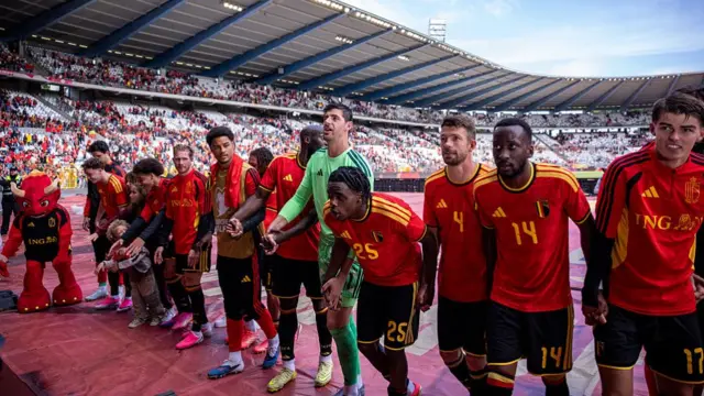 Belgian players in a line interacting with fans
