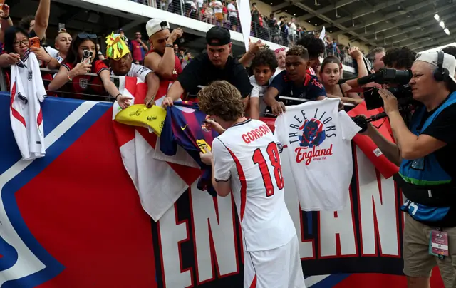 Anthony Gordon signs a fan's Barcelona shirt