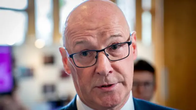 Scotland's First Minister John Swinney, an older, bald man with glasses.