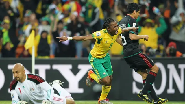 Siphiwe Tshabalala of South Africa celebrates after scoring the opening goal while Ricardo Osorio (R) and goalkeeper Oscar Perez of Mexico look dejected during the 2010 FIFA World Cup South Africa