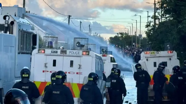Police deploy a water cannon against rioters in Belfast.