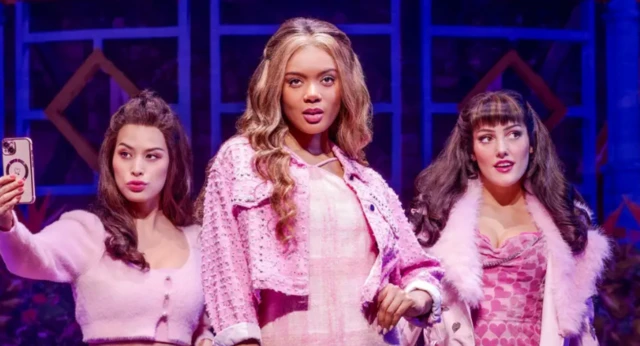 Three actresses dressed in coordinating pink outfits