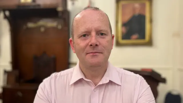 Ron McDowell, wearing a pink shirt.