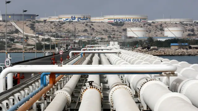 View of the Kharg Island oil terminal in the Persian Gulf, Iran. Rows of large white pipelines run over a causeway