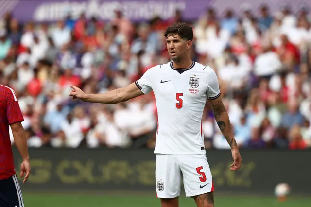 John Stones holds out his arm