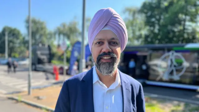 Headshot of Tan Dhesi who smiles at camera while standing out side