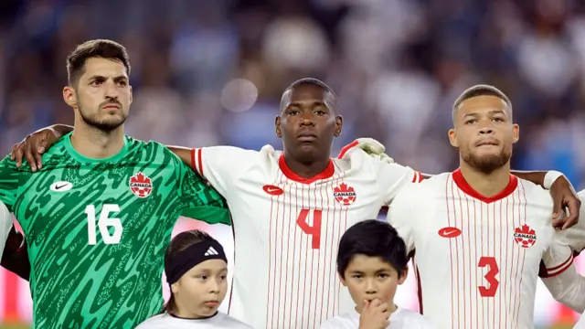 James Pantemis #16, Kamal Miller #4 and Zorhan Bassong #3 of Canada during the national anthem before a game against Guatemala in the second half at BMO Stadium on January 17, 2026 in Los Angeles, California. (