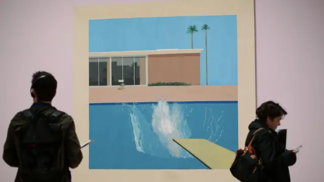 Visitors standing next to A Bigger Splash, 1967, as part of the David Hockney exhibition in 2017.