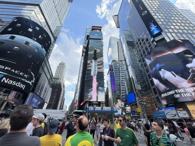 The three main advertising screens of Times Square filled with Space X content at the end of its first day of trading on the stock exchange