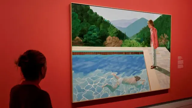 A visitor looks at a painting named 'Portrait Of An Artist (Pool with two Figures)' during an exhibition.