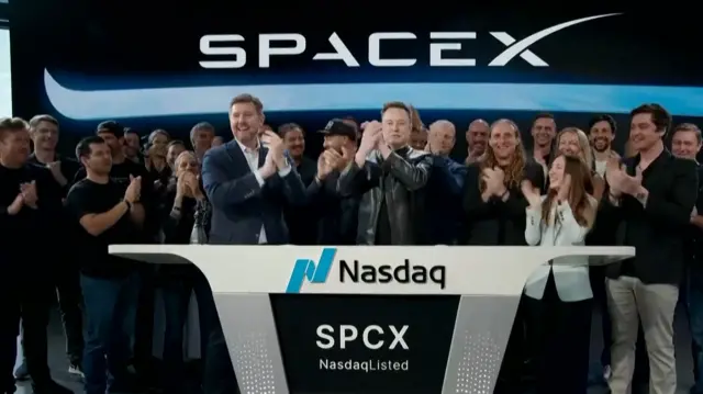 Elon Musk and other SpaceX workers celebrate as the company begins trading shares publically