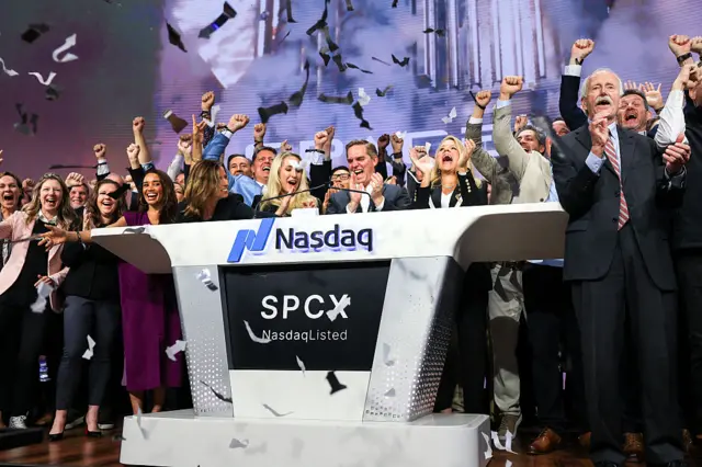 Bret Johnsen (C), SpaceX Chief Financial Officer, and Gwynne Shotwell (center R), SpaceX President and Chief Operating Officer, celebrate as they ring the opening bell at the Nasdaq MarketSite to celebrate the launch of SpaceX's initial public offering